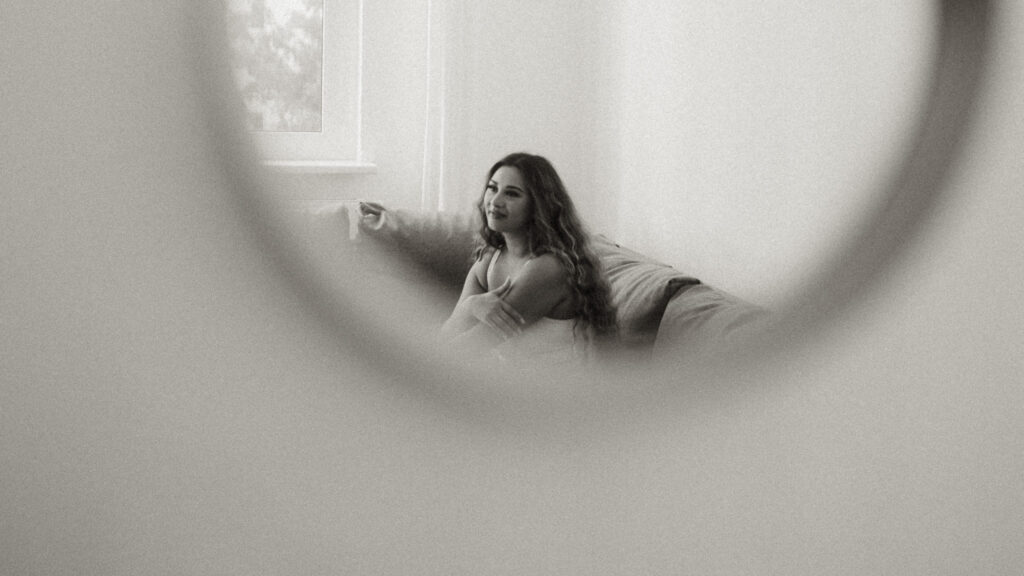 Bride looking off to the side, reflection in the mirror